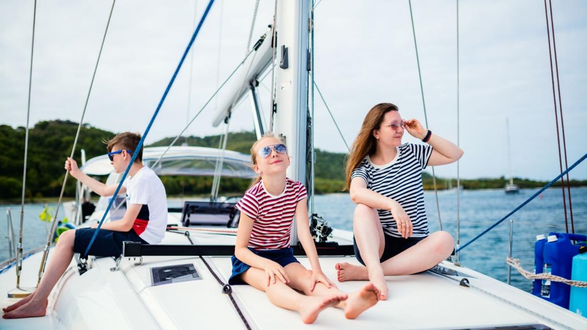 Eine Familie entspannt sich mit einer Sonnenbrille auf dem Deck eines gemieteten Bootes.